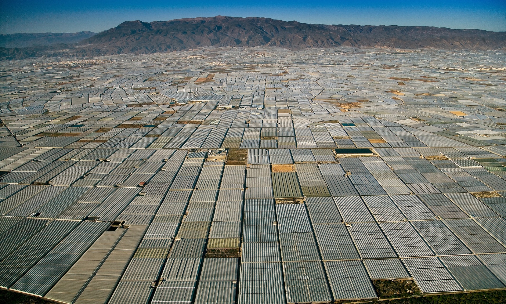 Sejauh mata memandang, rumah kaca menutup sebuah daratan luas di Almeria, Spanyol. - Photograph: Yann Arthus Bertrand