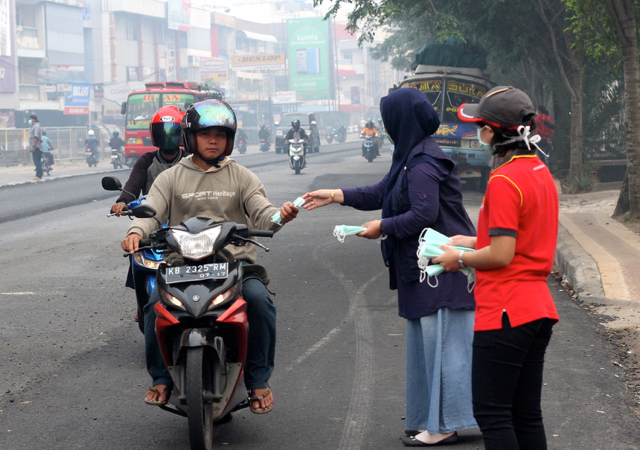Palang Merah Indonesia bersama Pemerintah  Kalbar dan sejumlah elemen masyarakat membagi-bagikan masker kepada pengendara sepeda motor di Pontianak. Foto: Andi Fachrizal