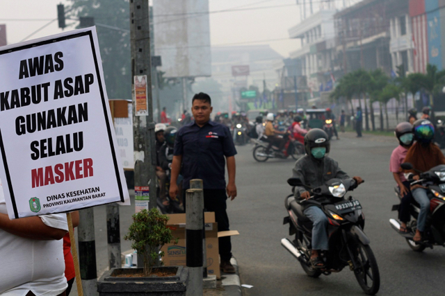 Dinas Kesehatan Kalimantan Barat menyebar imbauan bahaya asap dan menganjurkan pengendara bermotor untuk menggunakan masker. Foto: Andi Fachrizal