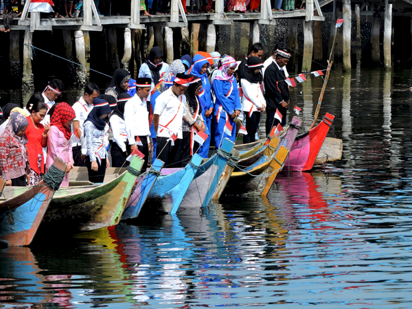 Warga Bajo mengheningkan cipta. Mereka melakukan upacara di atas perahu. Foto: Christopel Paino