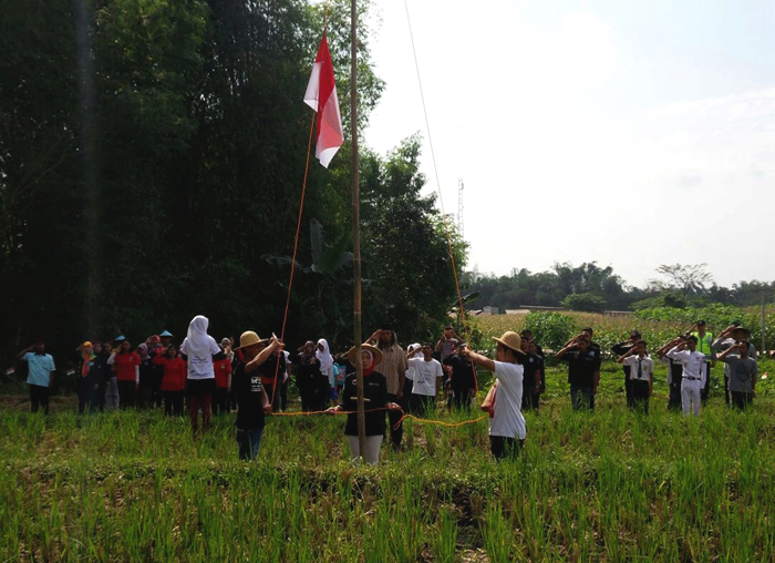 Upacara bendera di area persawahan yang diikuti berbagai komunitas muda-mudi di Magetan. Foto: Komunitas Perpustakaan Dbuku