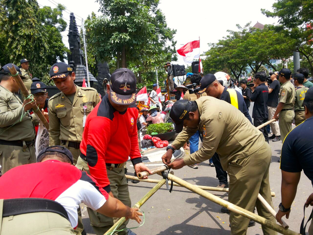 Satpol PP kala membongkar tenda warga Rembang yang aksi protes mendesak pencabutan izin baru yang dikeluarkan Gubernur kepada Semen Indonesia. Foto: JMPPK