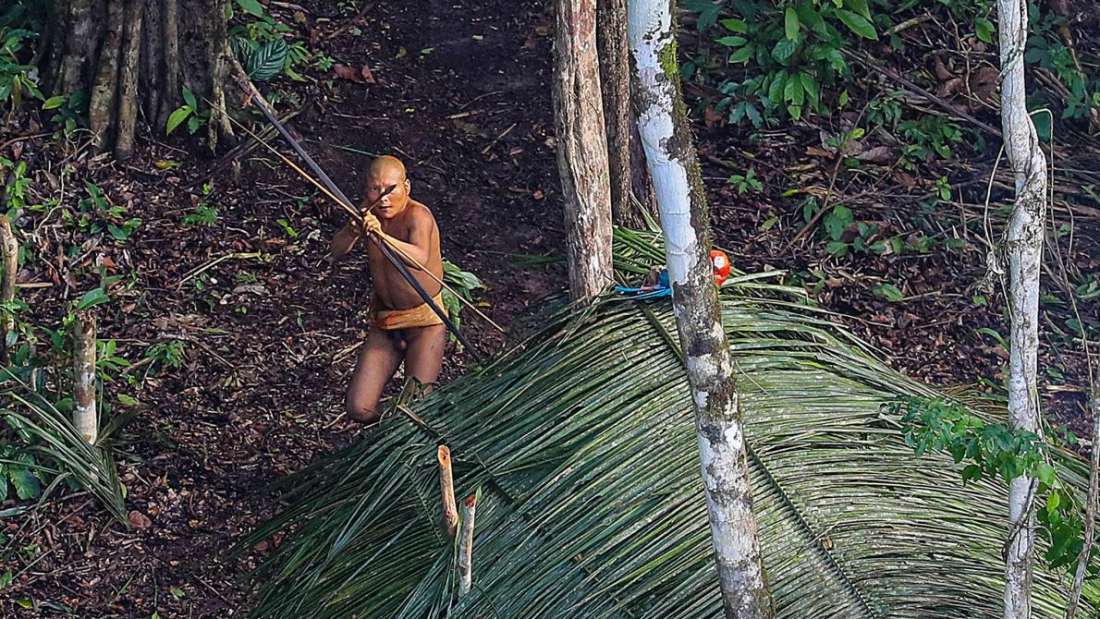 Anggota suku asli di Amazon yang terlihat mengusung busur panah, mengarahkan ke helikopter yang memotretnya. Foto: Ricardo Stuckert