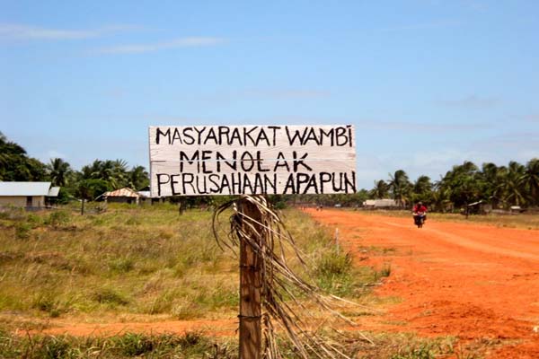 A sign in the Indonesian village of Wambi in Papua province's Merauke district says locals reject the presence of any company. Merauke is the site of a planned food and energy megaproject that was shelved during the Yudhoyono presidency but has been revived by the Jokowi administration. Photo: Agapitus Batbual