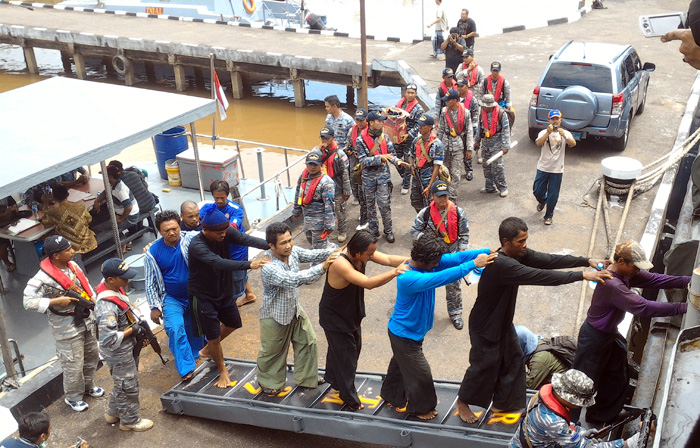 The crew of five illegal foreign fishing vessels are transferred to an Indonesian warship.