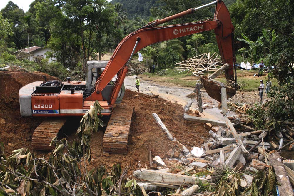 Alat berat diterjunkan untuk membersihkan longsor yang merubuhkan rumah warga di Desa Lamsujeun, Kecamatan Lhoong, Kabupaten Aceh Besar, Aceh, saat terjadi bencana tersebut beberapa waktu lalu. Foto: Junaidi Hanafiah