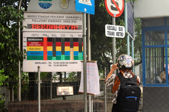 Seorang warga tampak tengah mengambil gambar papan ISPU yang menunjukkan level berbahaya dengan ponselnya. Foto: Nurul Fitria