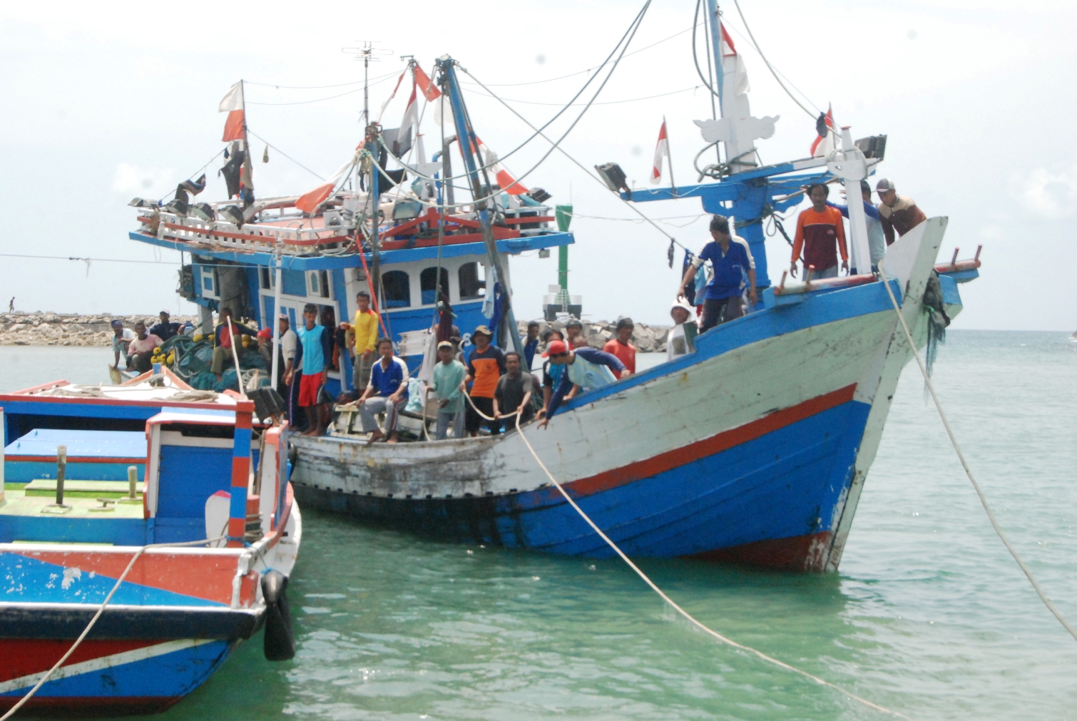 Nelayan bersiap dalam kapal yang sedang merapat di Pelabuhan Perikanan Sadeng, Gunung Kidul, Yogyakarta pada awal Desember 2015. Nelayan merupakan profesi yang riskan akan kecelakaan dan kematian, sehingga pemerintah berupaya memberikan asuransi nelayan. Foto : Jay Fajar