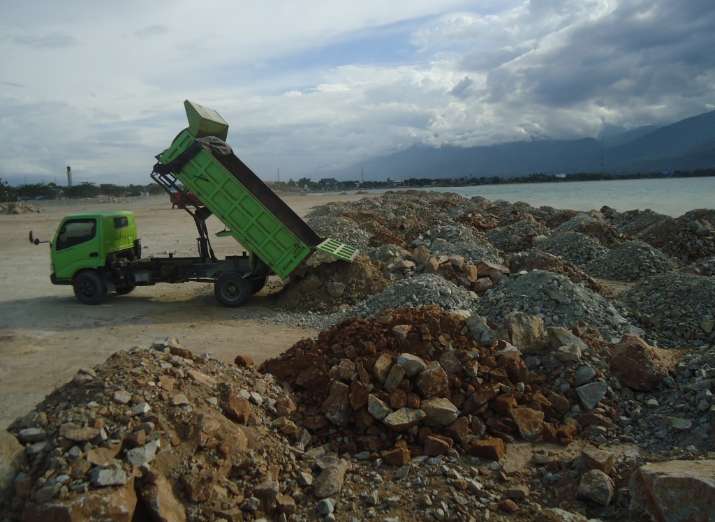Aktivitas truk menumpahkan material untuk reklamasi di Teluk Palu, Sulawesi Tengah. Berbagai pihak menentang reklamasi Teluk Palu karena merusak lingkungan. Foto : Themmy Doaly