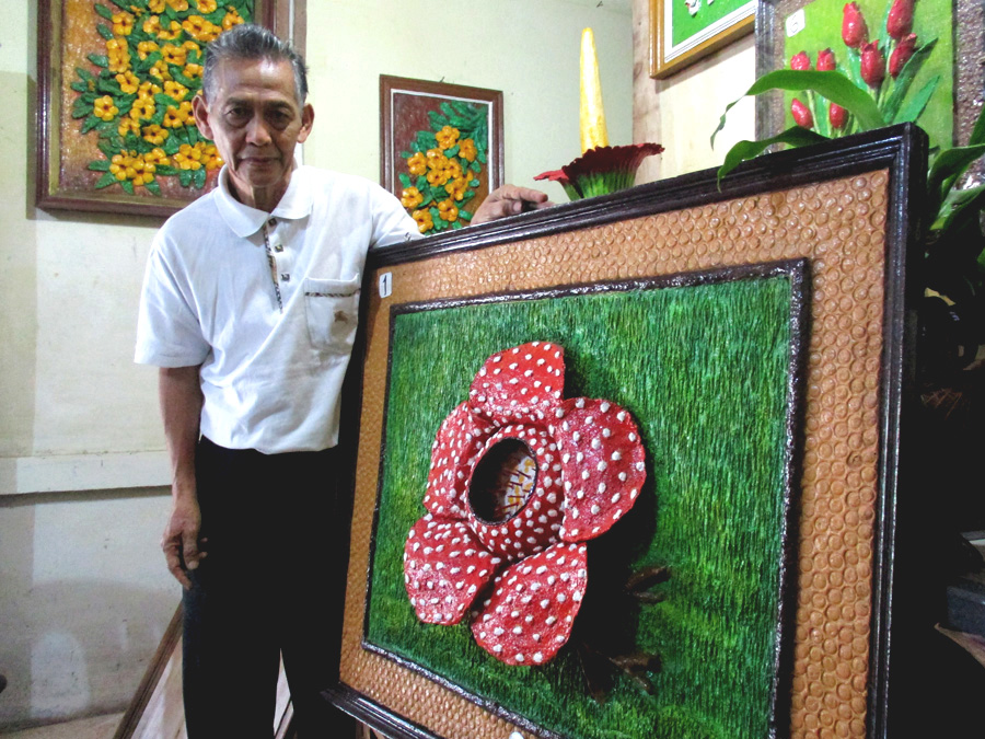 Amir menunjukkan lukisan 3 dimensi bunga Rafflesia. Foto: Dedek Hendry