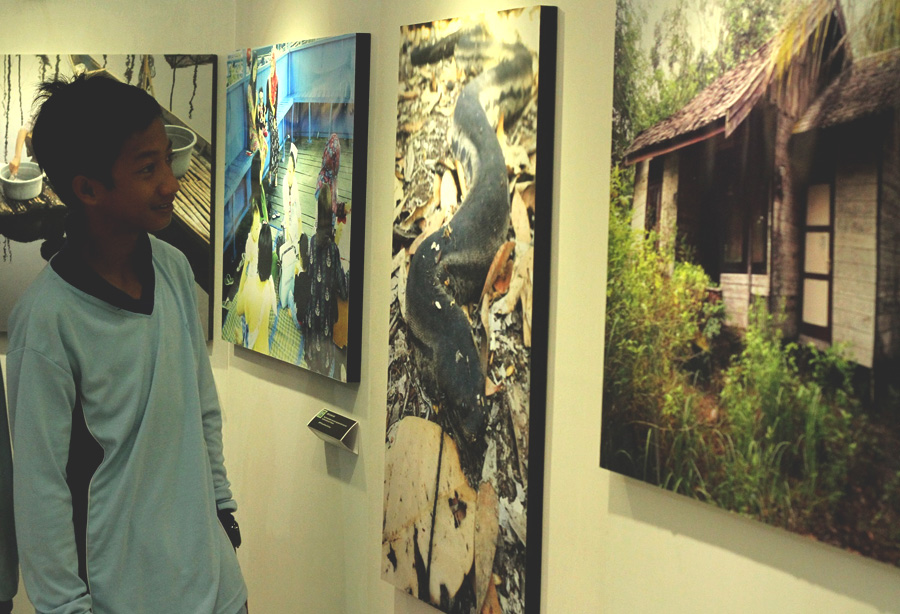 Seorang pelajar sedang menyaksikan beragam foto yang disajikan ke hadapan publik dalam Pameran Fotografi Panda CLICK! WWF-Indonesia Program Kalteng. Foto: Andi Fachrizal