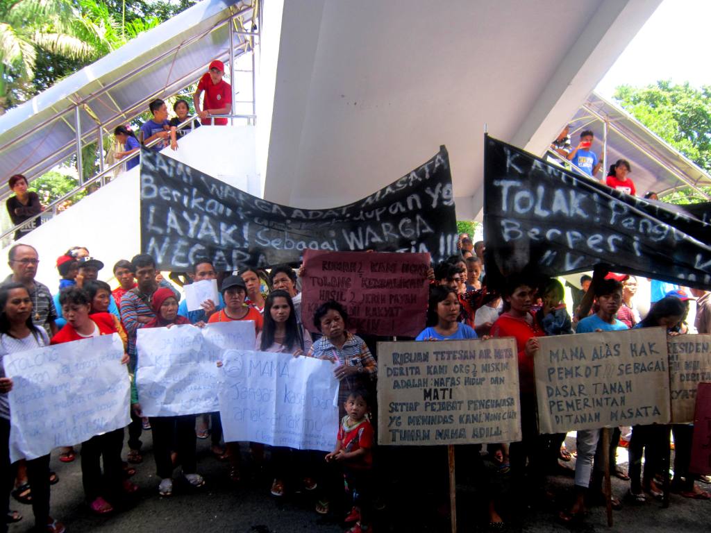 Aksi warga Kelurahan Tanjung Merah, Kecamatan Matuari, Kota Bitung, Sulawesi Utara pada Selasa (23/02/16) di depan Kantor Walikota Bitung. Mereka menolak penggusuran wilayah mereka untuk pembangunan Kawasan Ekonomi Khusus (KEK). Foto : LBH Manado