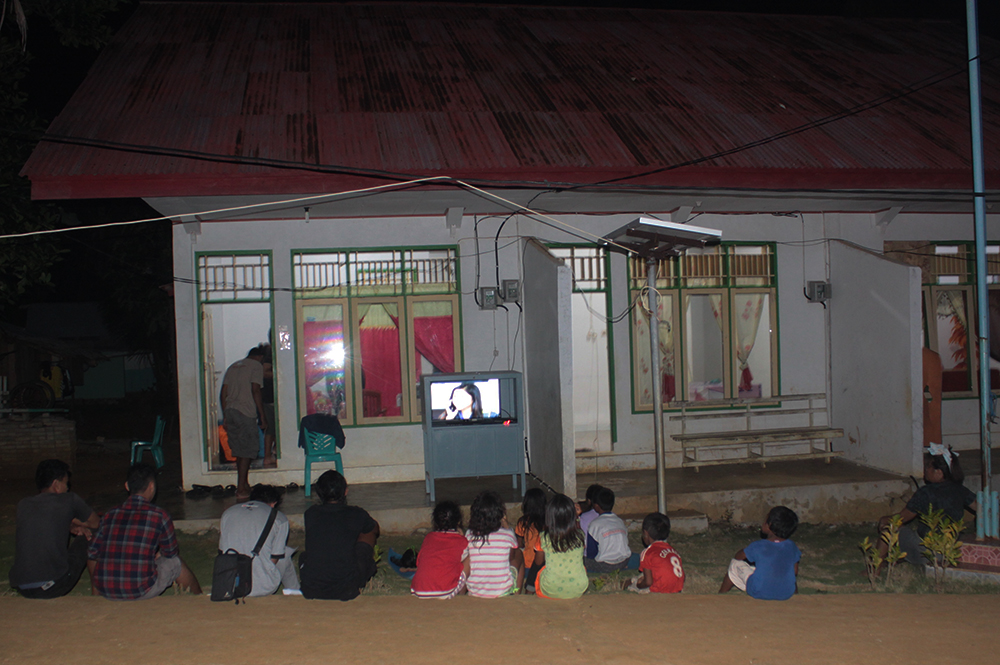 Warga menonton TV bersama di Pulau Matutuang, Kabupaten Kepulauan Sangihe, Sulut. Pulau Matutuang merupakan salah satu gugusan pulau terdepan di sebelah utara Indonesia dengan pasokan listrik dari PLTS tenaga surya yang dibuat oleh Kementerian ESDM dan KKP. Foto : Agustinus Wijayanto