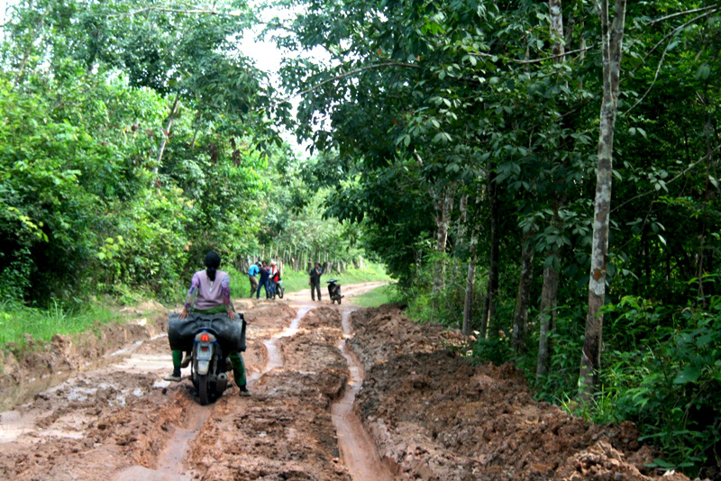 Warga menggunakan kendaraan bermotor melalui jalan desa yang sebagian besar rusak atau belum diaspal. Foto: Taufik Wijaya