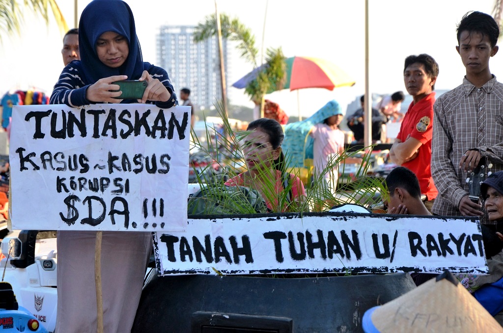 Peserta aksi dalam rangka memperingatai Hari Lingkungan Hidup 2016 memegang spanduk di acara Car Free Day di Pantai Losari, Makassar, Sulawesi Selatan, pada Minggu (5/6/2016) . WALHI Sulsel mencatat sejumlah kasus konflik SDA di Sulsel periode 2014-2016, berdampak pada 6.188 jiwa terdiri dari 1.007 nelayan dan 5.161 petani dan masyarakat adat. Foto : Wahyu Chandra