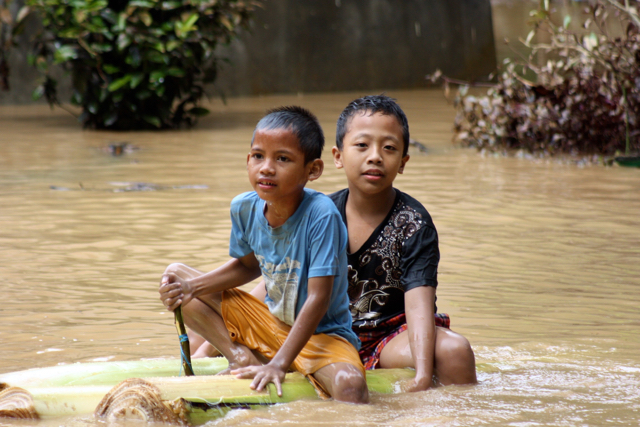Dua bocah bermain air kala banjir di Bagelen, Purworejo. Foto: Nuswantoro