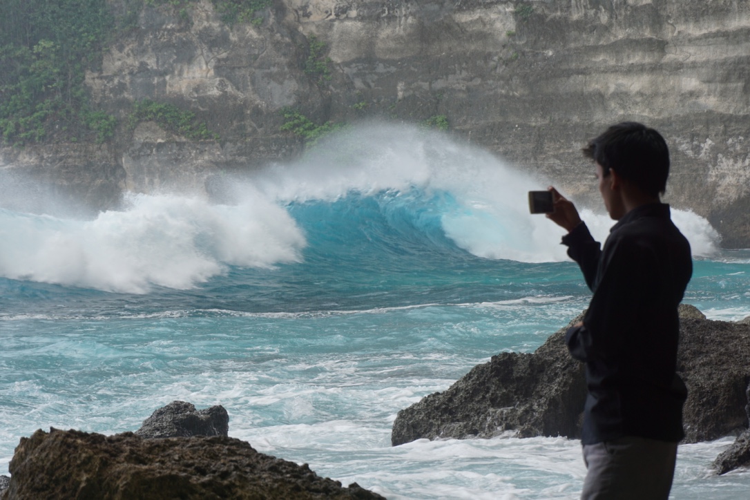 Pengunjung memotret gelombang tinggi yang menghantam tebing di Tembeling, Nusa Penida, Bali. Foto : Anton Muhajir