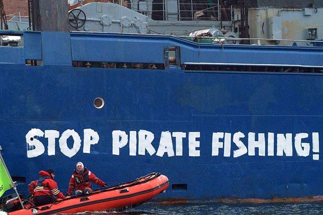 Aktivis Greenpeace menuliskan kata ‘stop pirate fishing’ pada sebuah kapal illegal. Foto : Greenpeace