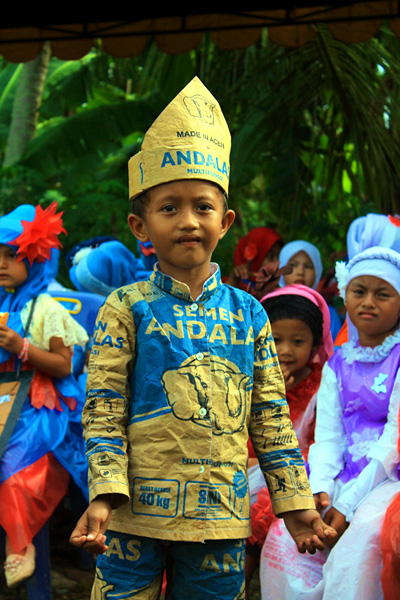 seorang anak terlihat menggunakan baju yang didesain dari kertas bekas. Foto: Lembaga Pariwisata Nusa