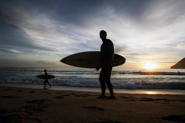 Selancar air yang dilakukan pengunjung merupakan olahraga favorit di pantai Lampuuk. Foto: Junaidi Hanafiah