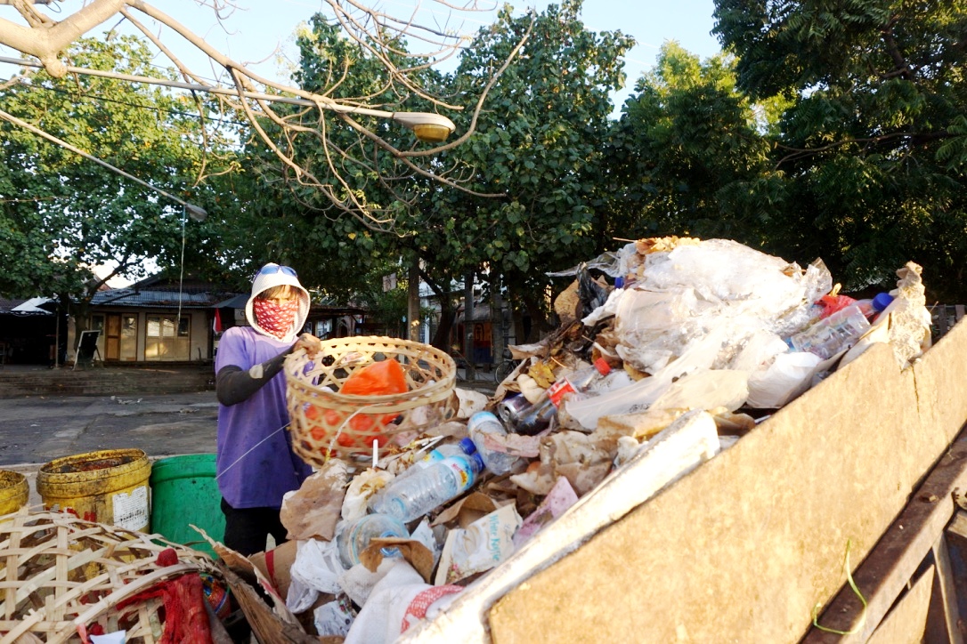 Labib, seorang petugas pengambil sampah mengumpulkan sampah ke cidomo di Gili Trawangan, NTB. Foto : Anton Muhajir