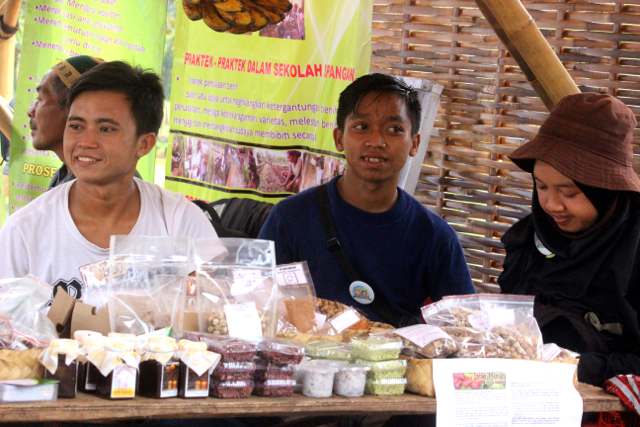 Romdon, (berbaju putih) dengan beragam produk dari Saung Rangkai di Festival Desa. Foto: Sapariah Saturi