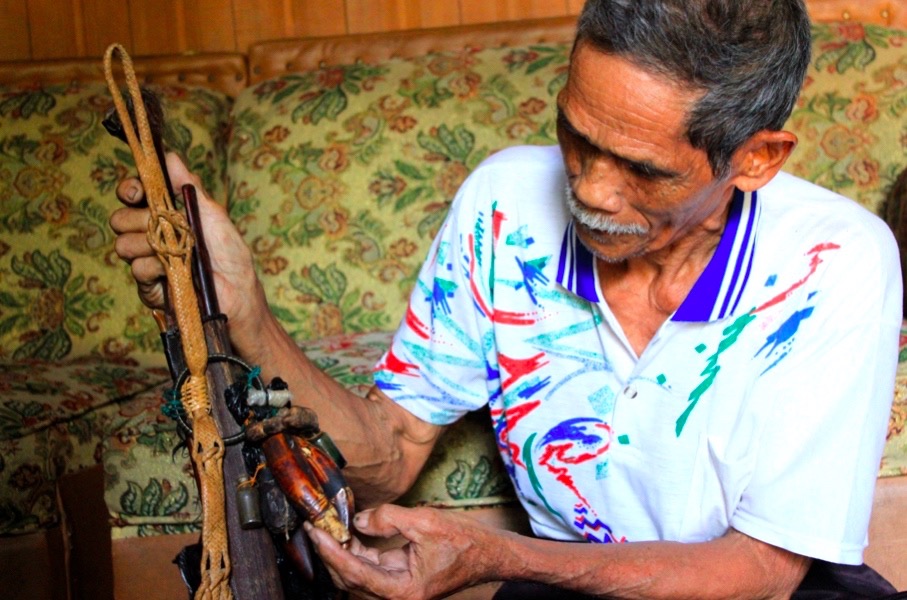 Iber Djamal, tokoh adat Dayak Ngaju, menunjukkan senjata mandau warisan leluhurnya yang dihiasi sejumlah taring hewan. Salah satu taring diklaim taring harimau. Foto Jemmie Delvian