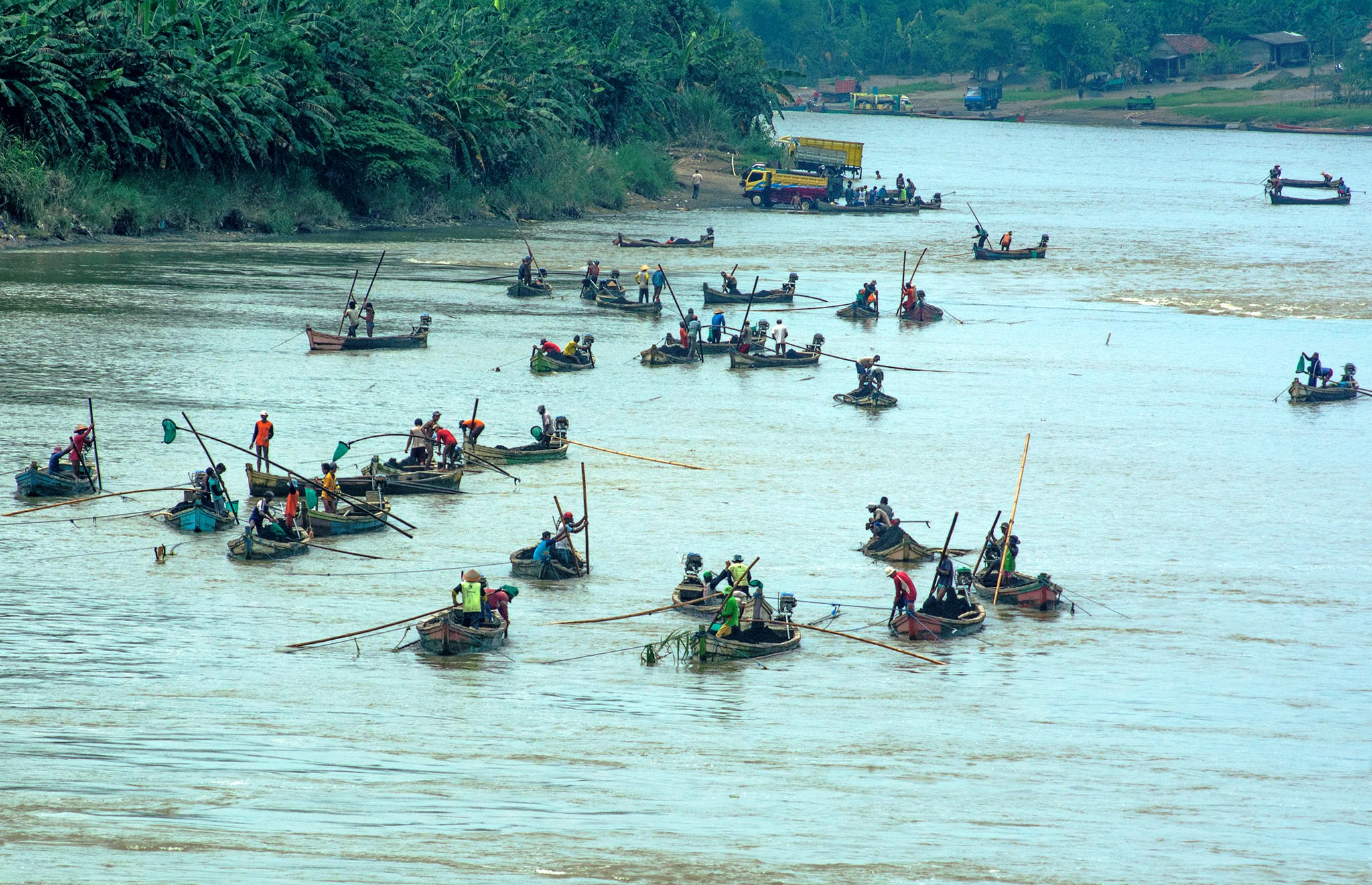 Puluhan perahu berisi penambang pasir yang tidak jauh dari Jembatan Soeharto, Rawalo, Banyumas, Jawa Tengah. Aktivitas penambangan pasir ini merugikan lingkungan karena meningkatkan abrasi di sepanjang DAS Serayu. Foto : L Darmawan