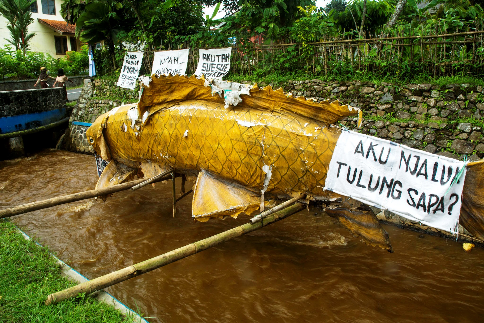 Warga Desa Karangtengah, Kecamatan Cilongok, Banyumas, Jateng membuat patung ikan dan memasang poster sebagai bentuk protes keruhnya air Sungai Prukut karena pembangunan jalan PLTP Baturraden. Foto : L Darmawan