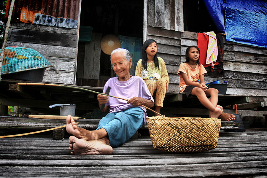 Unin (100 tahun) warga Kampung Semangit mengisi hari dengan membuat keranjang dari rotan. Kerajinan tangan ini kemudian akan dijual ke warga sekitar untuk digunakan sebagai tempat membawa ikan | Foto: Hs Poetra
