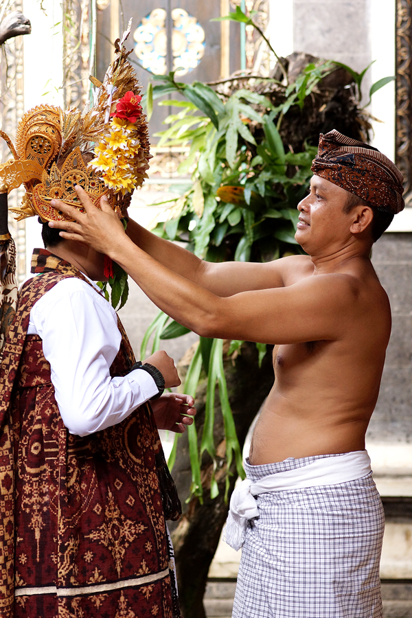 Seorang bapak mendandani anaknya sebelum mengikuti upacara adat matekruk di Tenganan Daud Tukad, Karangasem, Bali. Matekruk merupakan upacara adat prosesi kedewasaan bagi remaja Tenganan. Foto: Anton Wisuda/Mongabay Indonesia