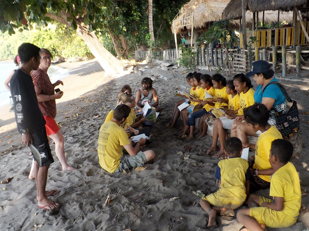 Anak-anak sedang membaca buku I’m Trash Hero bersama relawan komunitas Trash Hero Maumere pada kegiatan edukasi yang pengelolaan sampah di pantai Wairterang, Waigete kabupaten Sikka, Flores, NTT, Minggu (29/7/2018) | Foto: Ebed de Rosary/Mongabay Indonesia.