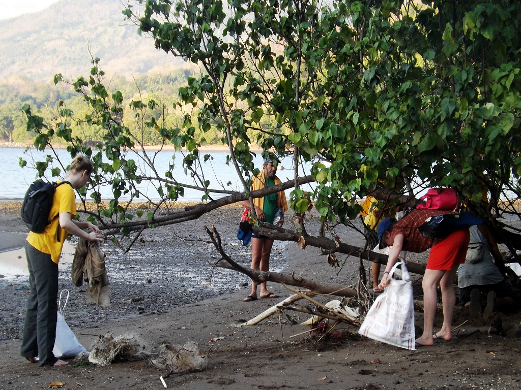 Wisatawan asing relawan komunitas Trash Hero sedang mengambil sampah dalam kegiatan Trash Hero Maumere di pantai Wairterang, Waigete, Sikka, Flores, NTT, Minggu (29/7/2018) | Foto: Ebed de Rosary/Mongabay Indonesia