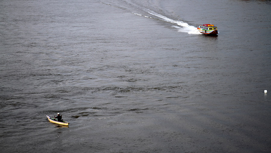 Nelayan yang masih bertahan di Palembang. Nelayan ini menjaring ikan di sela sibuknya lalu lintas air di Sungai Musi | Foto: Nopri Ismi