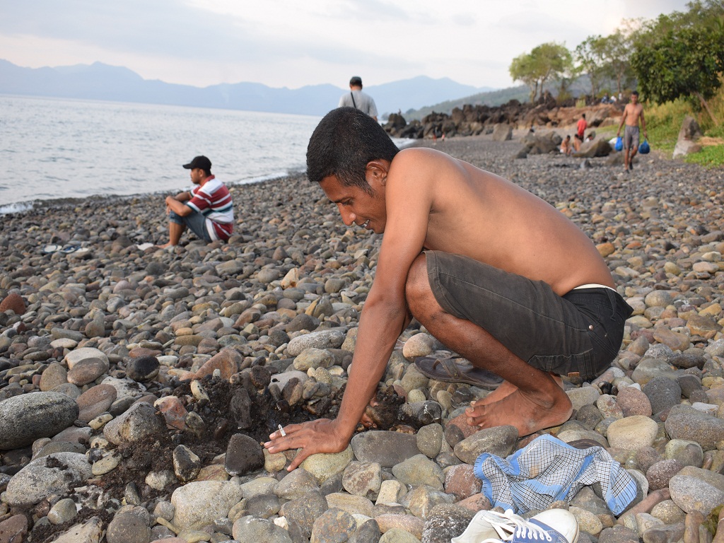 Pengunjung pantai Kawaliwu sedang menggali pasir yang akan dipergunakan sebagai lubang tempat merendam anggota tubuh. Foto : Ebed de Rosary/Mongabay Indonesia