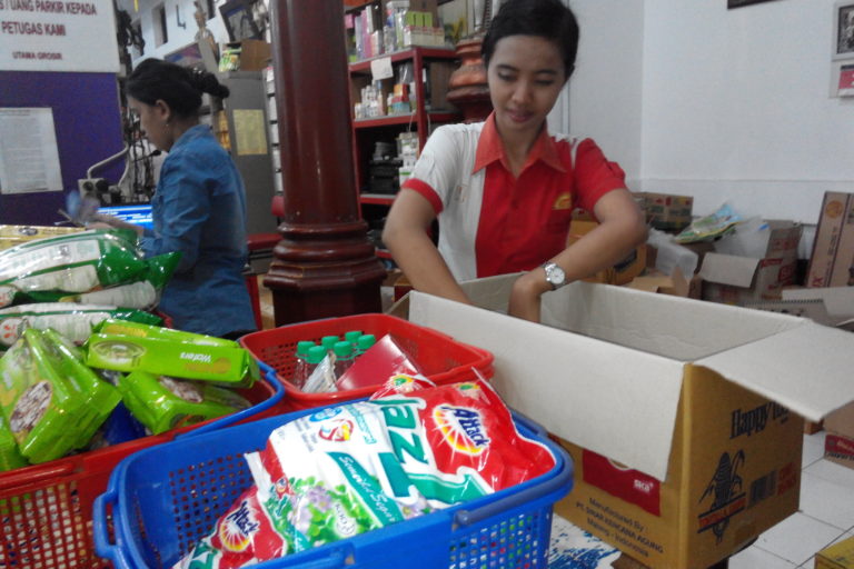 Pramuniaga Utama Grosir menata barang belanjaan pelanggan di dalam kardus bekas.Foto: Eko Widianto/ Mongabay Indonesia