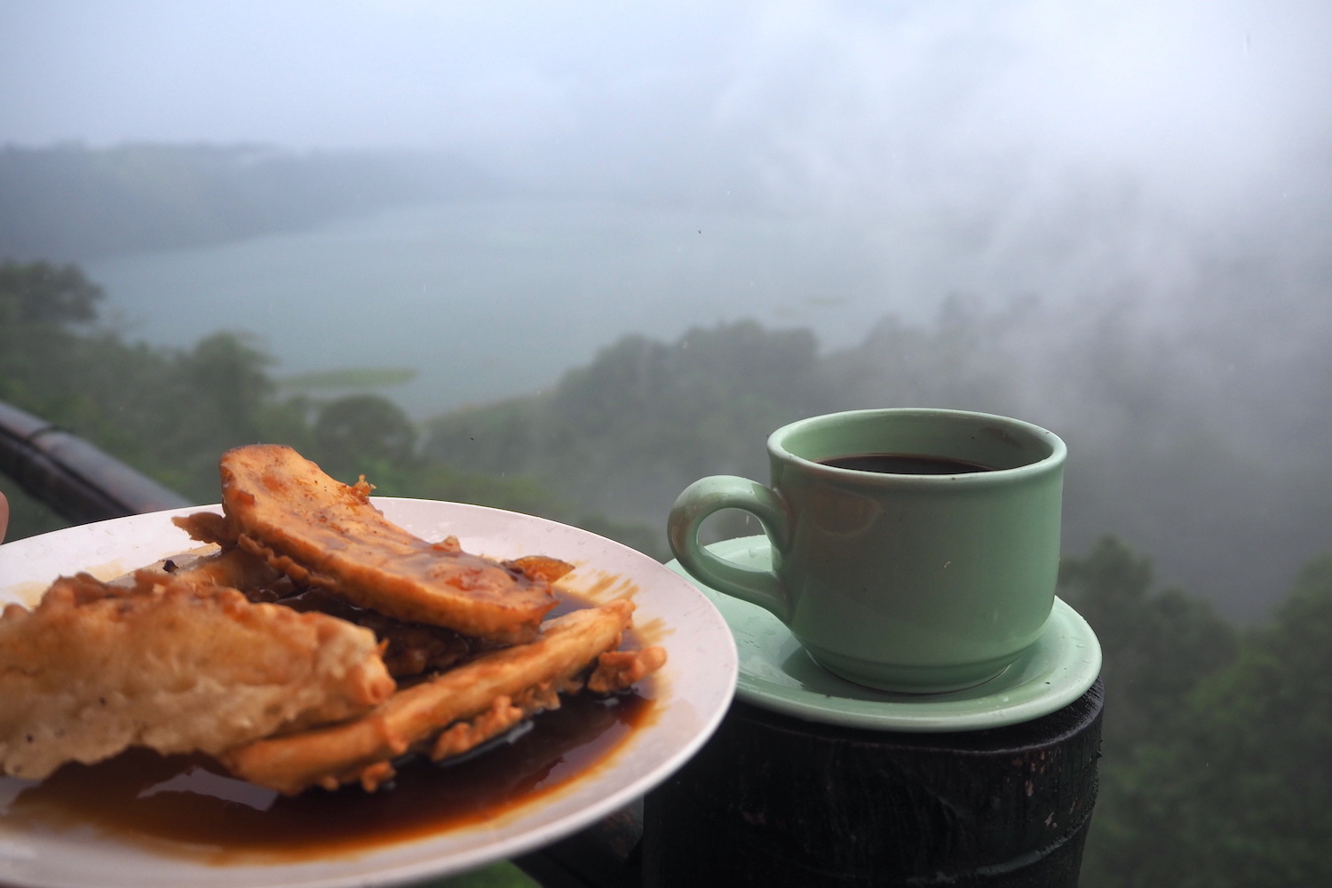 Secangkir kopi Robusta dari Buleleng dan pisang goreng menemani kabut saat memandangi panorama danau Buyan dan Tamblingan yang berdampingan dari kejauhan. Foto: Luh De Suriyani/Mongabay Indonesia