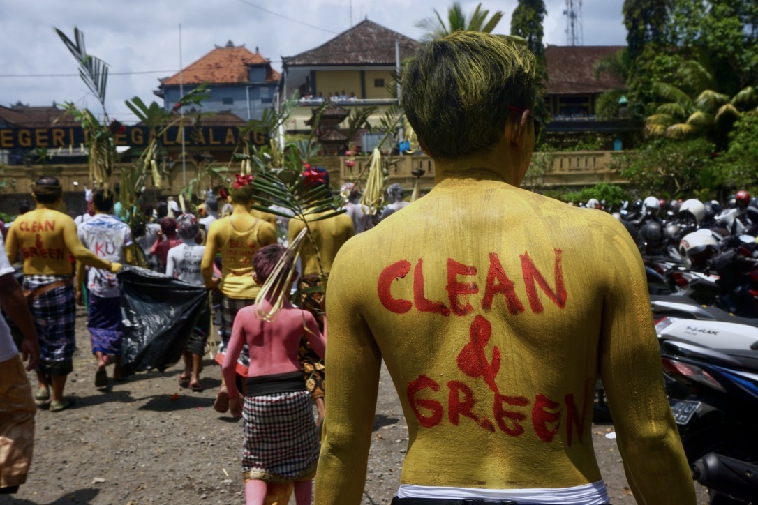 Seorang peserta parade Ngrebeg berkampanye lingkungan dengan mengecet tubuh bak poster berjalan | Foto: Luh De Suriyani/Mongabay Indonesia
