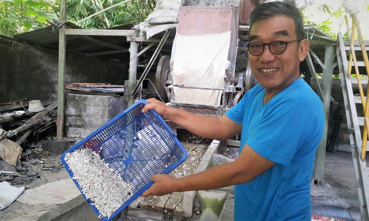 Boy Candra, memperlihatkan sampah plastik PVC yang baru selesai dihancurkan | Foto: Tommy Apriando/ Mongabay Indonesia