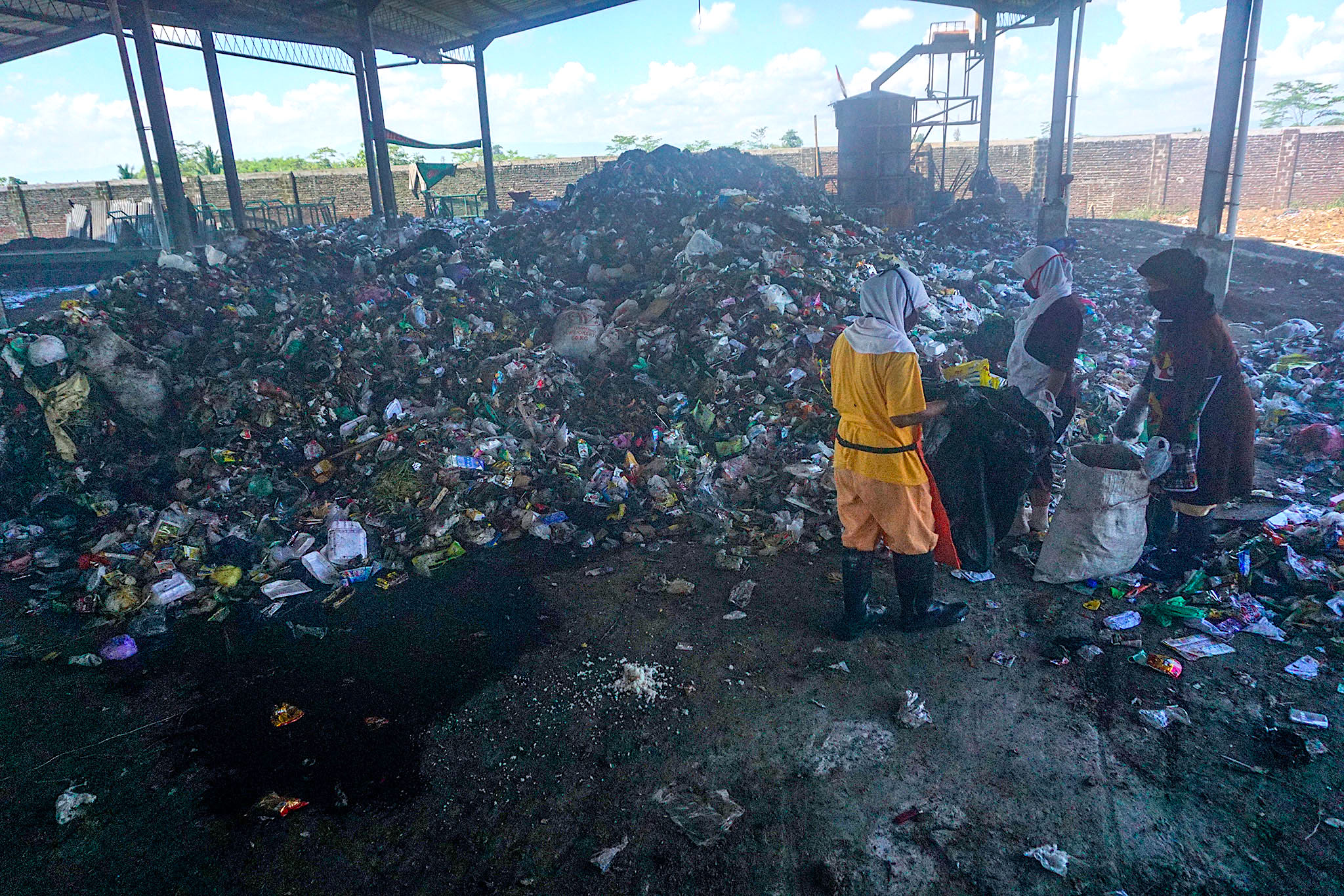 Sejumlah pekerja beraktivitas di hanggar tempat pengolahan sampah terpadu (TPST) Karangcegak, Kecamatan Sumbang, Banyumas | Foto: L Darmawan/Mongabay Indonesia