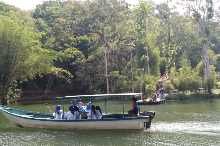 Perahu motor melintas di danau Boonpring, Sumber Andeman dengan hamparan hutan bambu di belakang. Foto: Eko Widianto/ Mongabay Indonesia