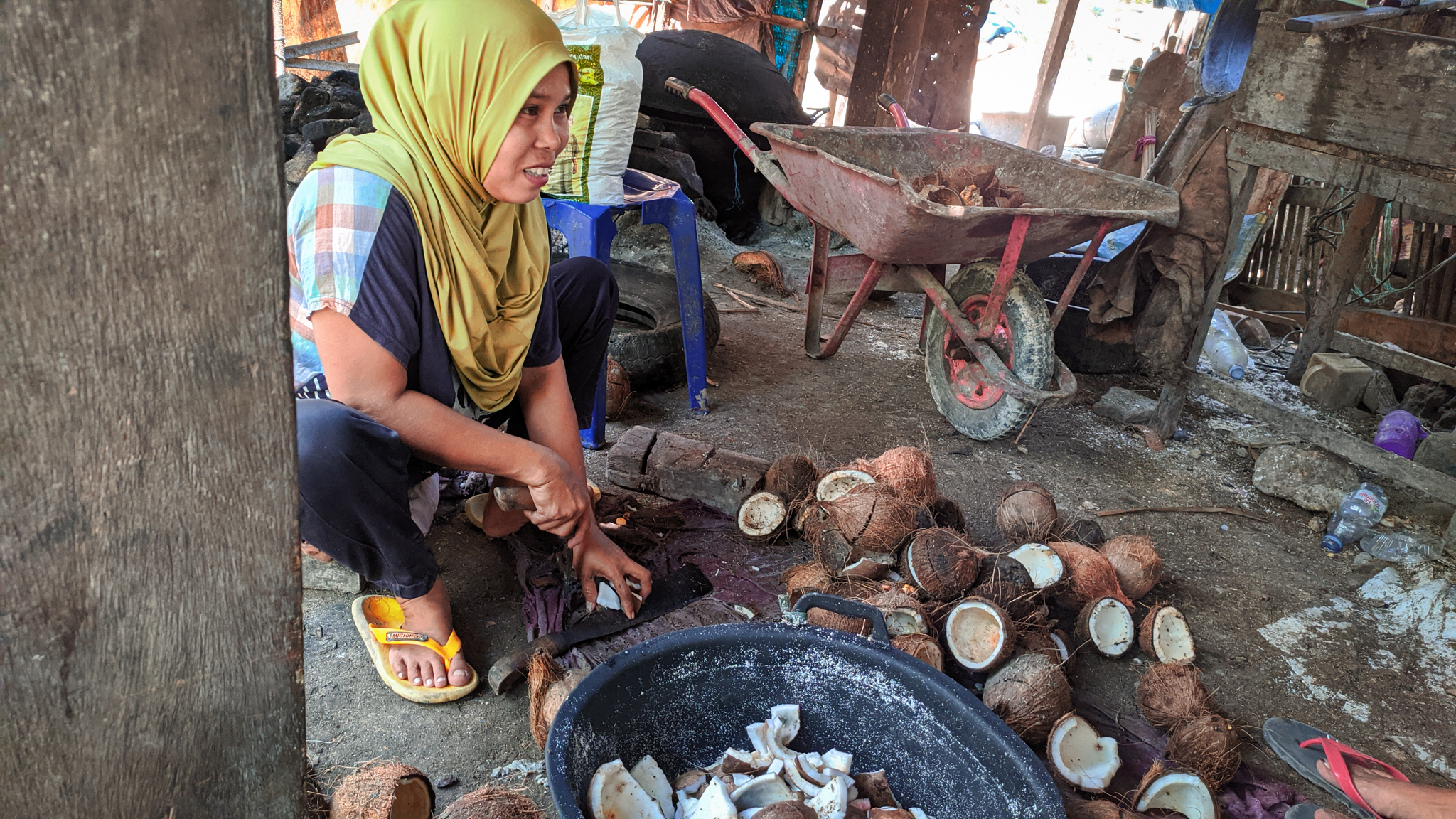 Proses mengambil daging kelapa untuk bikin minyak. Foto: Agus Mawan/ Mongabay Indonesia