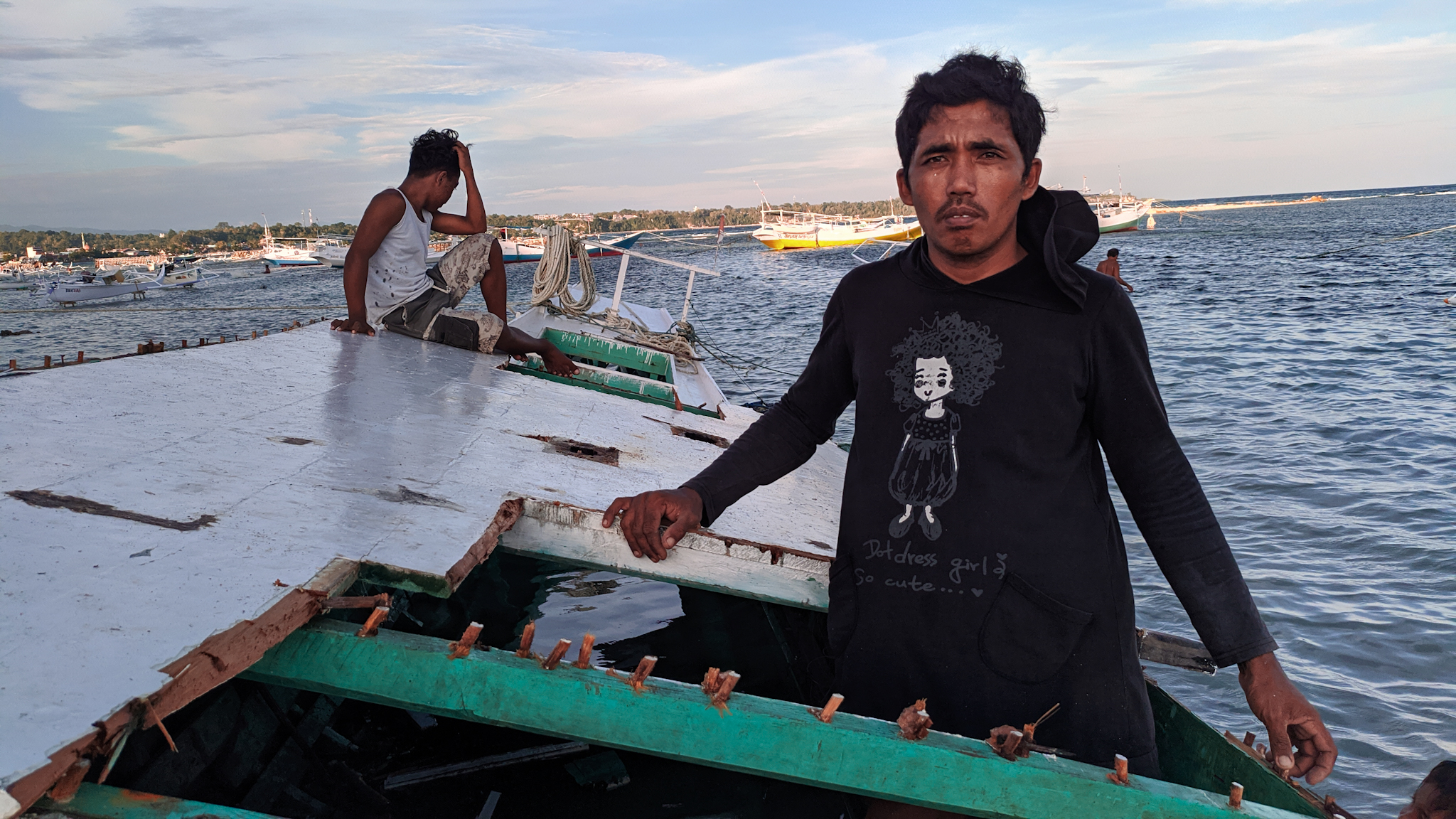 Ridwan Tajuddin berdiri di atas kapalnya . Foto: Agus Mawan./ Mongabay Indonesia