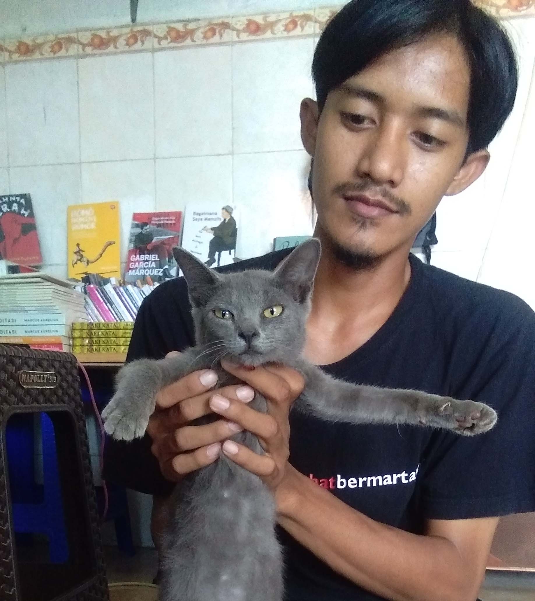 Zaenal dan kucing busok yang baru dia miliki lima bulan ini. Foto: Gafur Abdullah/ Mongabay Indonesia