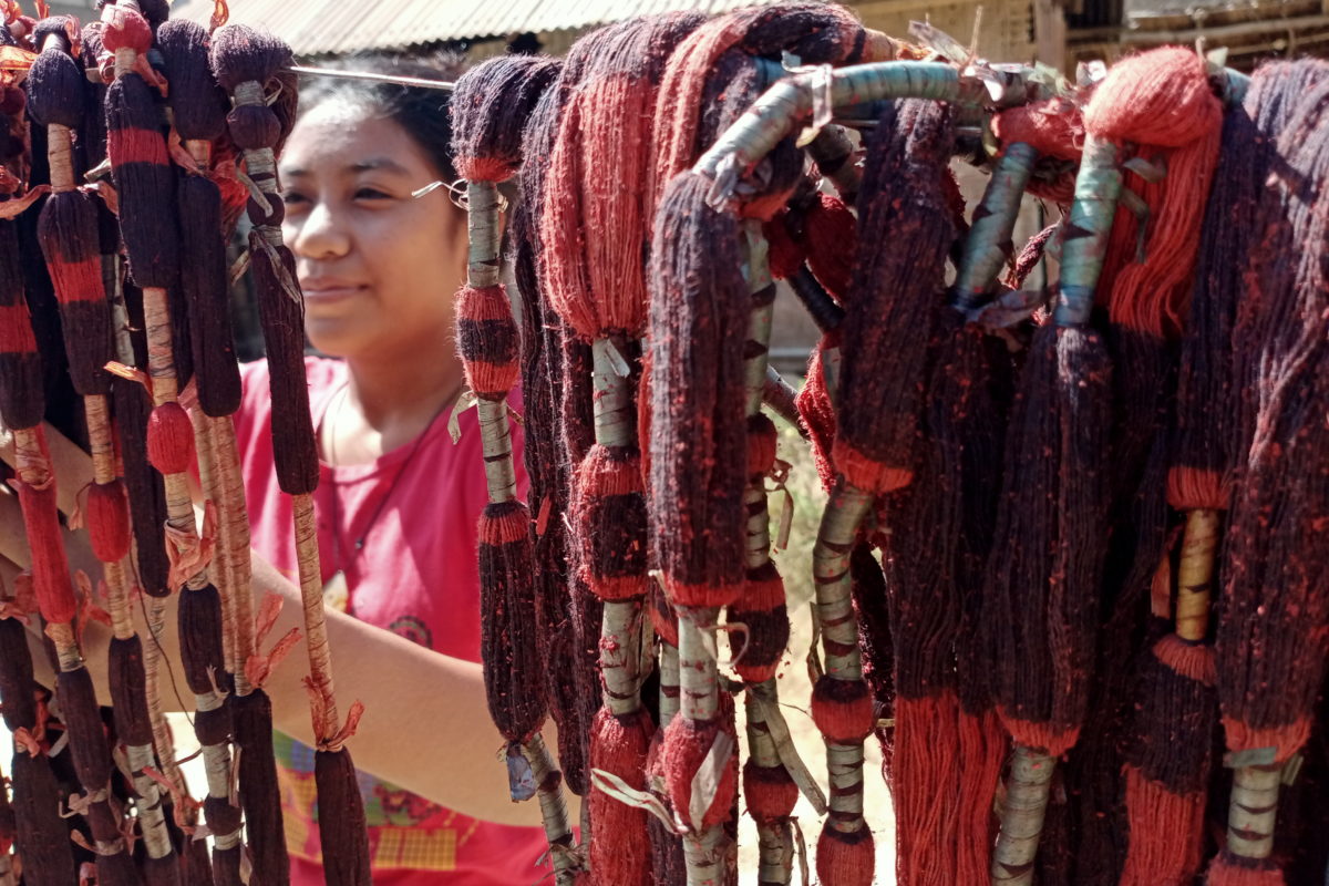Lusi, penenun muda yang sedang menjemur benang yang diwarnai. Foto: Diana Timoria