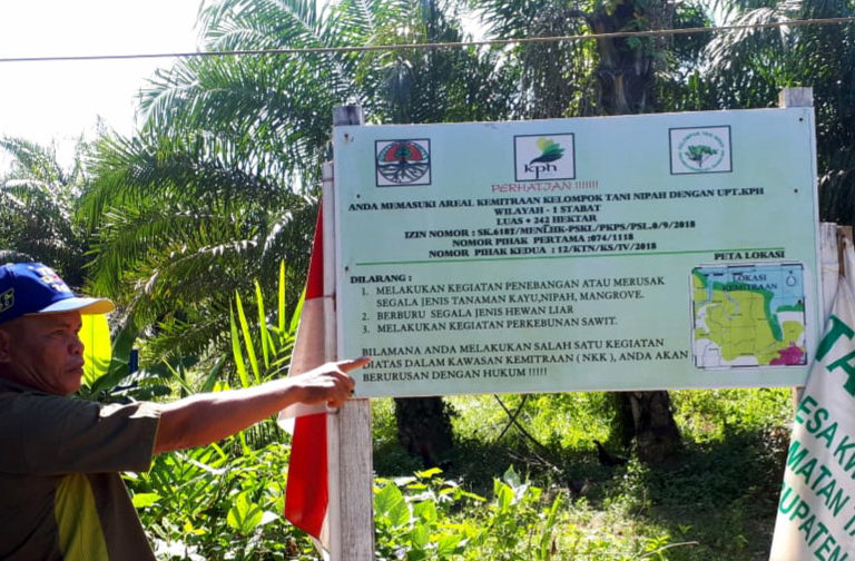 Samsul, Ketua Kelompok Tani Nipah, menumpuk plang yang berizi keterangan izin kelola kawasan hutan dari KLHK. Foto: Ayat S Karokaro/ Mongabay Indonesia
