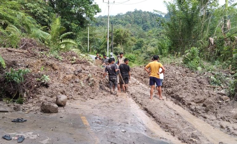 Warga sedang gotong royong membersihkan jalan Lintas Tapan Via Sungai Penuh KM 20 yang tertimbun lumpur akibat banjir Rabu 28 Maret. Foto: Vinolia.