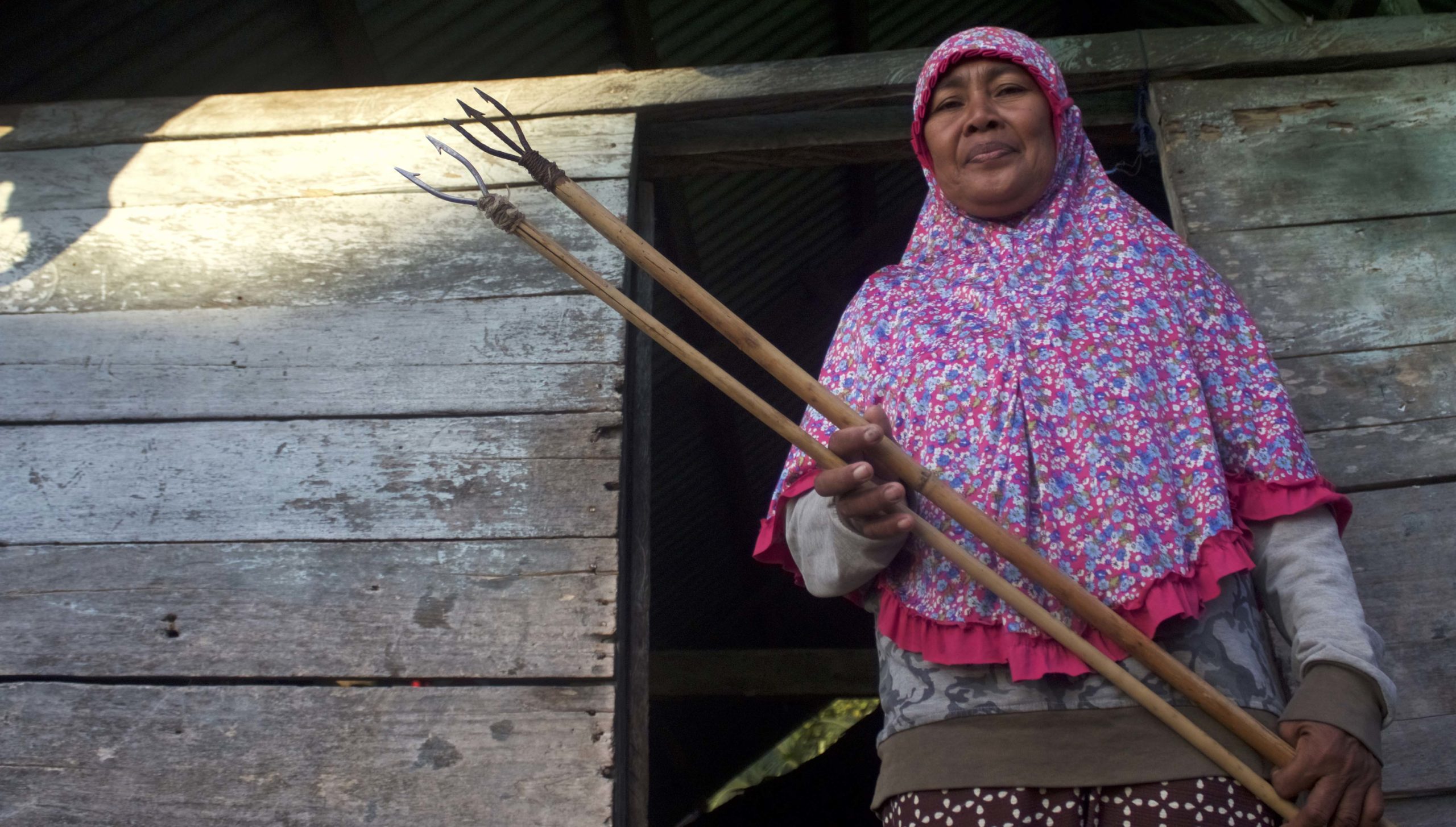 Saribulan(55) memegang tombak bersiap-siap turun ke laut menangkap ikan di perairan dangkal Desa Pesisir Labotaone, Teluk Moramo. Foto: Riza Salman