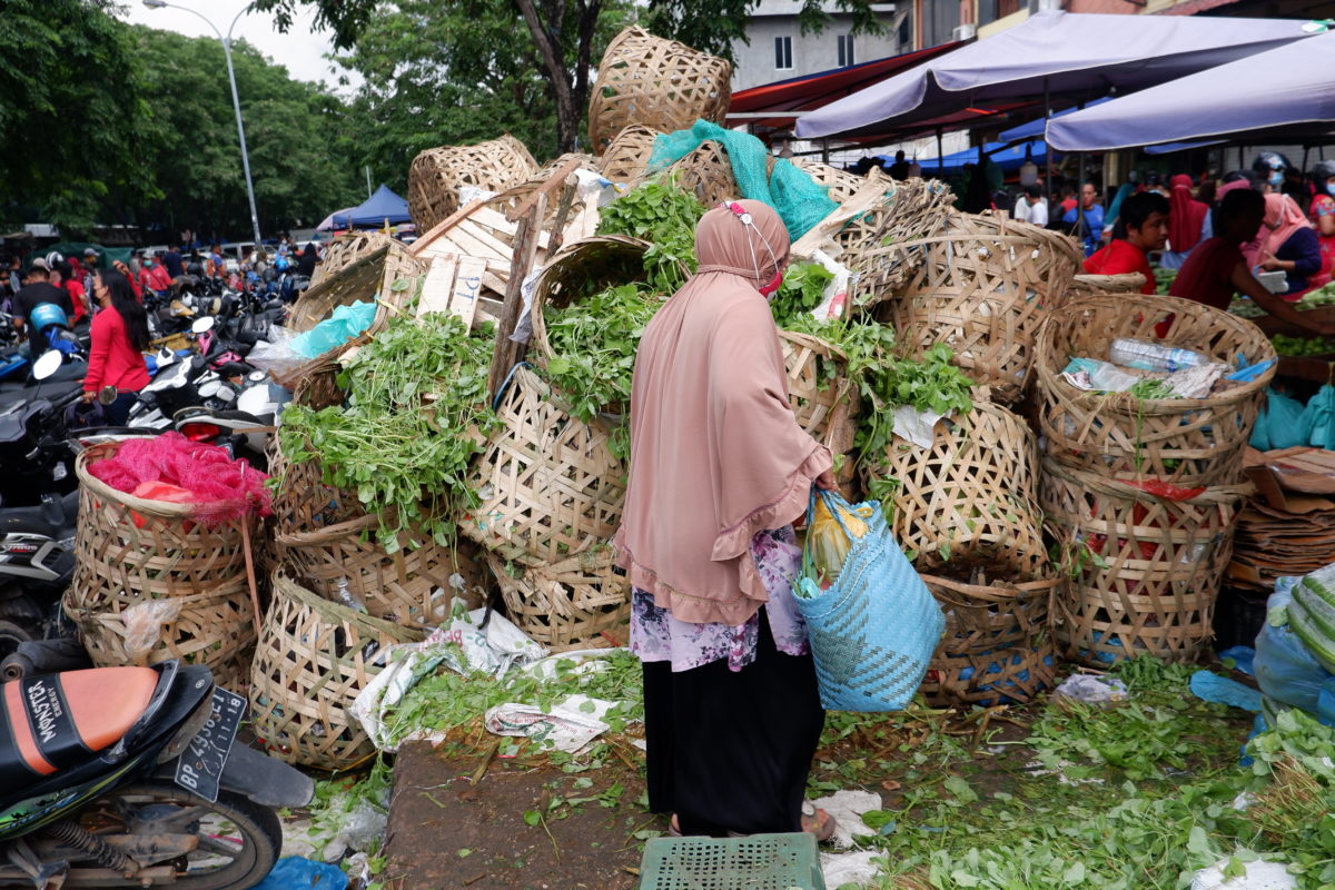 Seorang warga melintasi tumpukan sampah sayur-sayuran di Pasar Nagoya Jodoh Kota Batam. Foto: Yogi ES/ Mongabay Indonesia