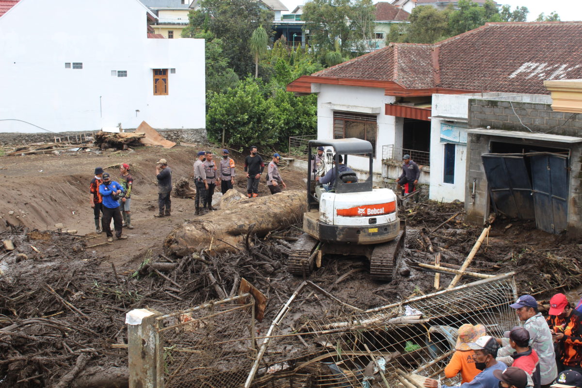 escavator menarik batang pohon raksasa yang menerjang Desa Bulukerto, Kecamatan Bumiaji, Kota Batu. (Foto: Eko Widianto).